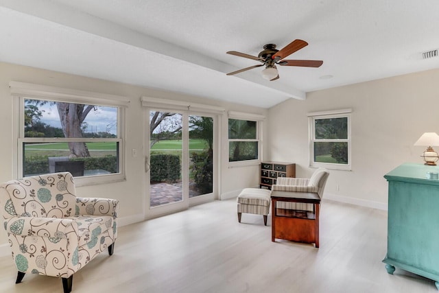 sitting room with baseboards, vaulted ceiling with beams, a ceiling fan, and light wood-style floors