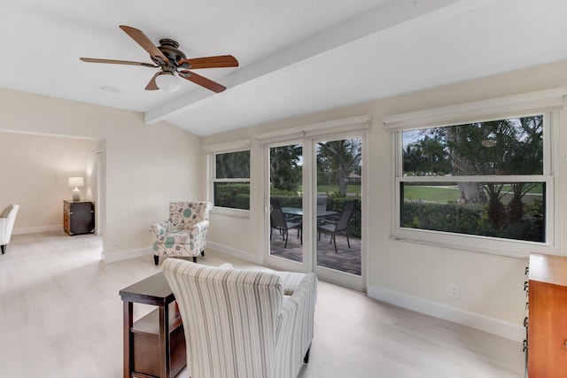 living area with vaulted ceiling with beams, light wood finished floors, baseboards, and a ceiling fan