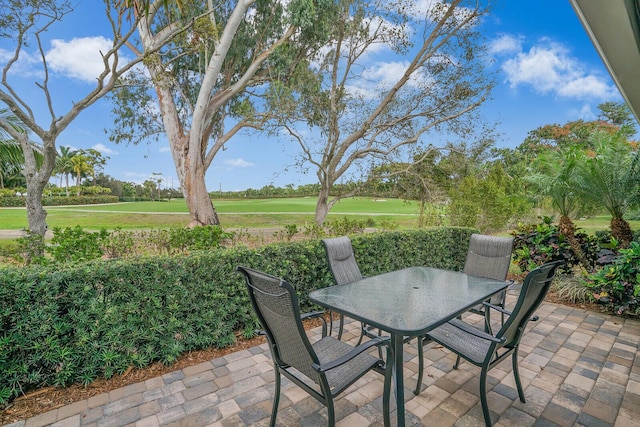 view of patio featuring view of golf course and outdoor dining space