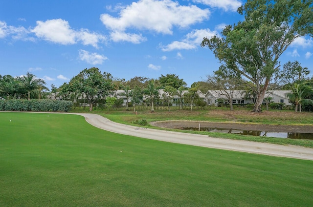 surrounding community featuring a water view and a lawn