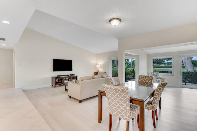 dining space with lofted ceiling, recessed lighting, visible vents, a textured ceiling, and baseboards