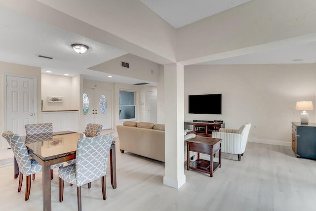 dining space with light wood-style floors, visible vents, and baseboards