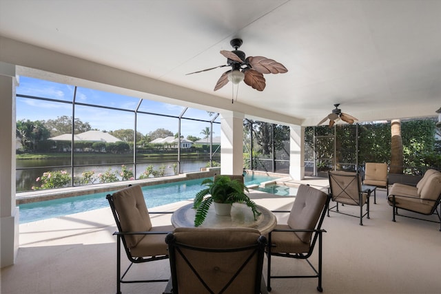 sunroom featuring ceiling fan, a swimming pool, and a water view