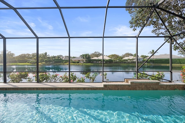 view of swimming pool with glass enclosure and a water view