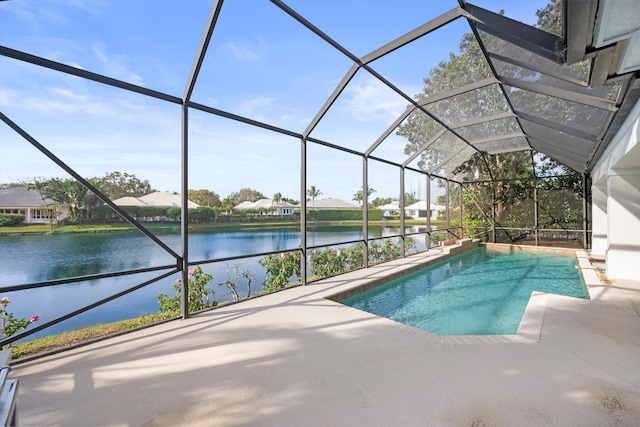 view of pool with glass enclosure, a patio area, and a water view