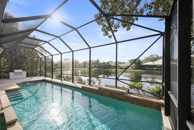 view of swimming pool featuring a lanai, a water view, exterior kitchen, and a patio