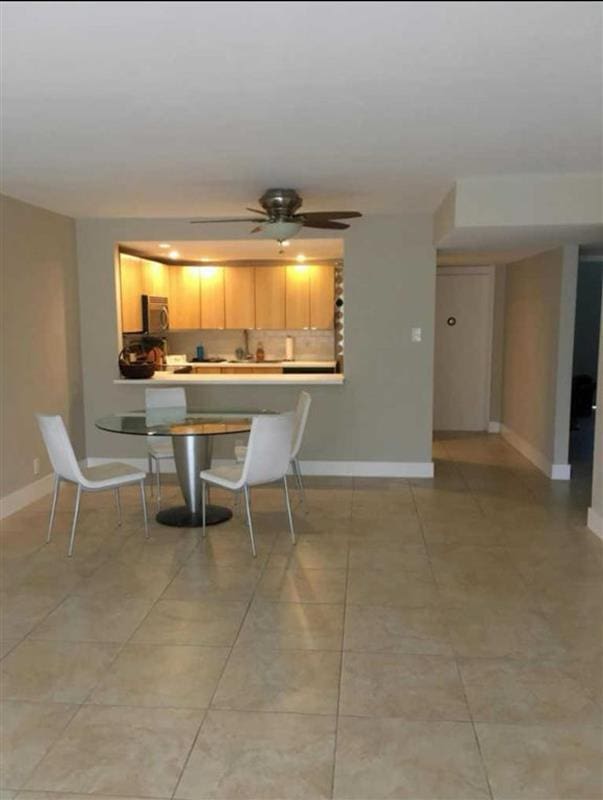 dining space with light tile patterned floors and ceiling fan