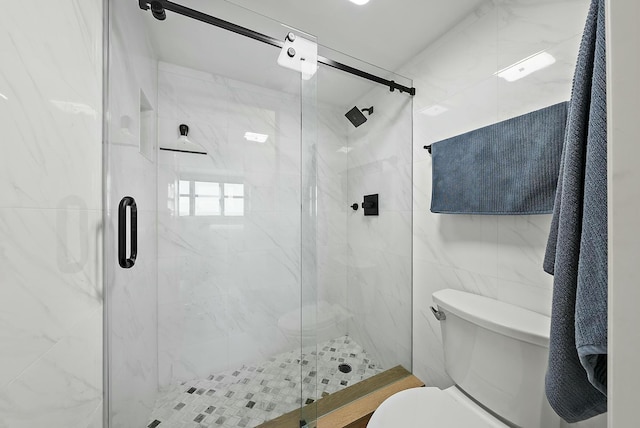 bathroom featuring a shower with shower door, tile walls, and toilet