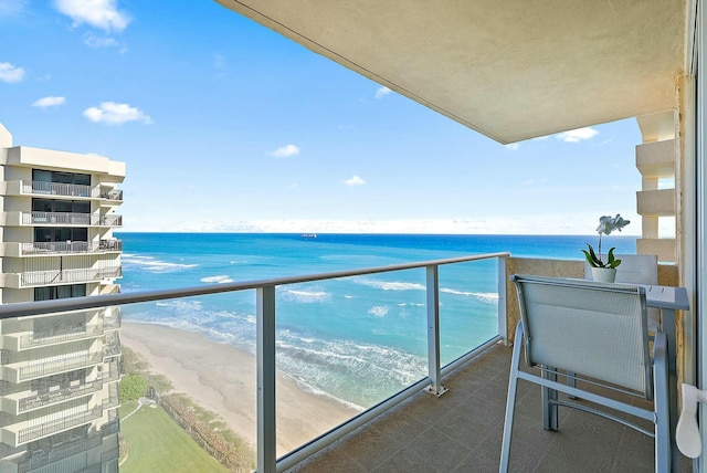 balcony featuring a water view and a beach view