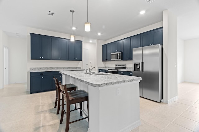 kitchen featuring stainless steel appliances, blue cabinets, sink, light tile patterned floors, and an island with sink