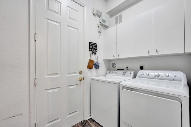 clothes washing area featuring cabinets, dark hardwood / wood-style floors, and washer and dryer