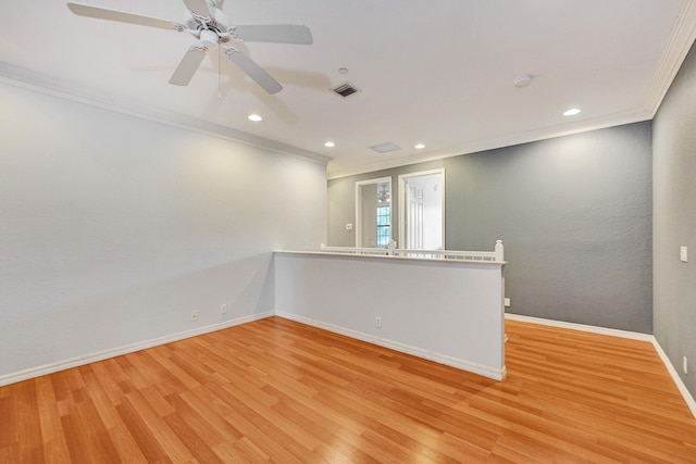 empty room featuring light wood-type flooring, ceiling fan, and crown molding