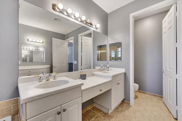 bathroom with tile patterned flooring, vanity, and toilet