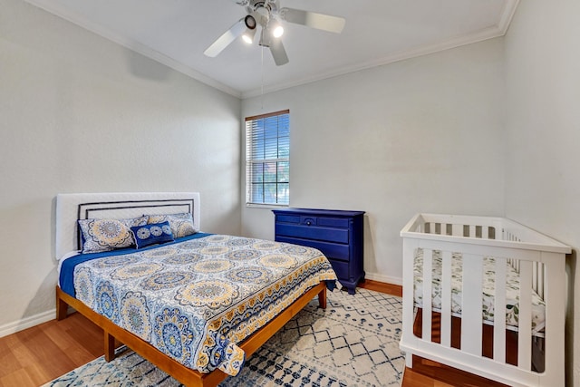 bedroom featuring wood-type flooring, ceiling fan, and crown molding