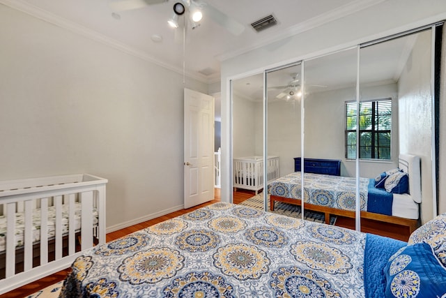 bedroom with hardwood / wood-style floors, ceiling fan, ornamental molding, and a closet