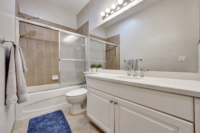 full bathroom featuring shower / bath combination with glass door, tile patterned floors, vanity, and toilet