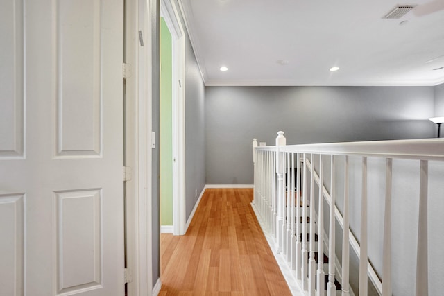 hall featuring crown molding and light hardwood / wood-style flooring