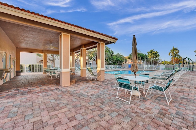 view of patio with ceiling fan and a community pool