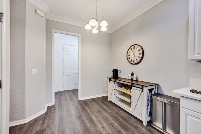 interior space featuring a chandelier, dark hardwood / wood-style floors, and crown molding