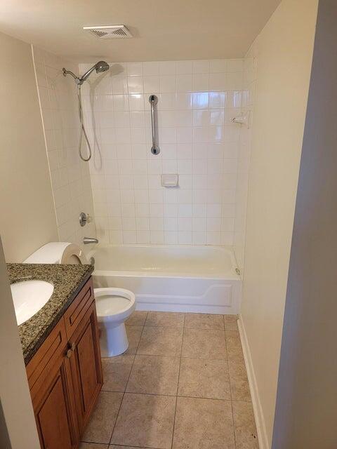 full bathroom featuring tile patterned flooring, vanity, toilet, and tiled shower / bath