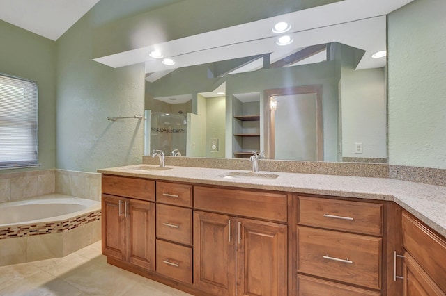 bathroom with tile patterned floors, vanity, and shower with separate bathtub