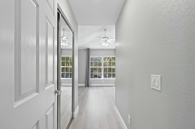 hall featuring light hardwood / wood-style flooring and lofted ceiling