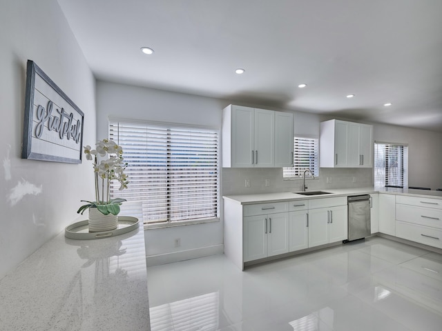 kitchen with tasteful backsplash, sink, white cabinets, and a healthy amount of sunlight