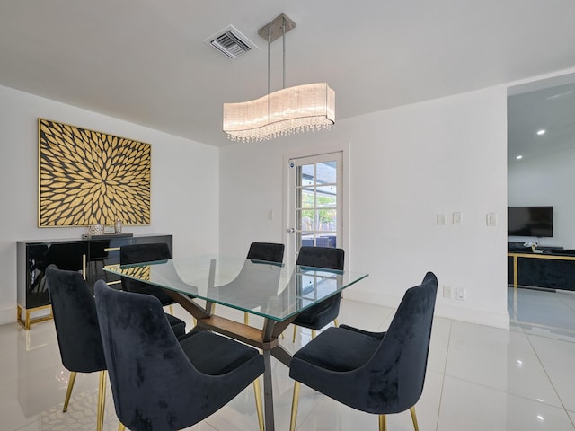 tiled dining room featuring a chandelier