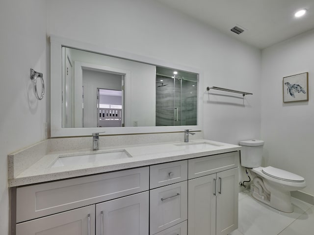 bathroom featuring tile patterned floors, vanity, toilet, and a shower with shower door