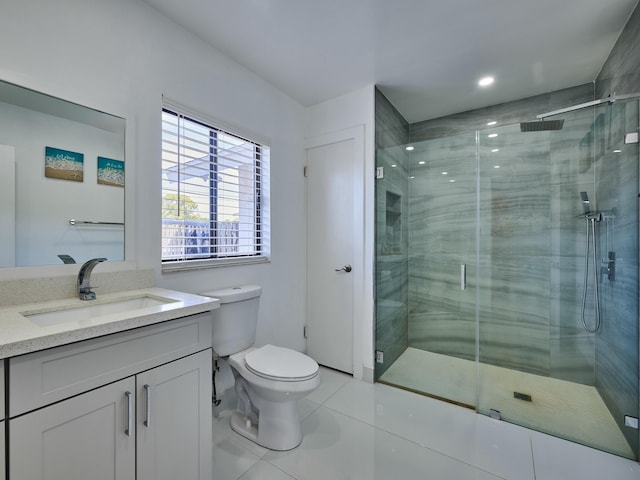 bathroom with tile patterned flooring, vanity, toilet, and walk in shower