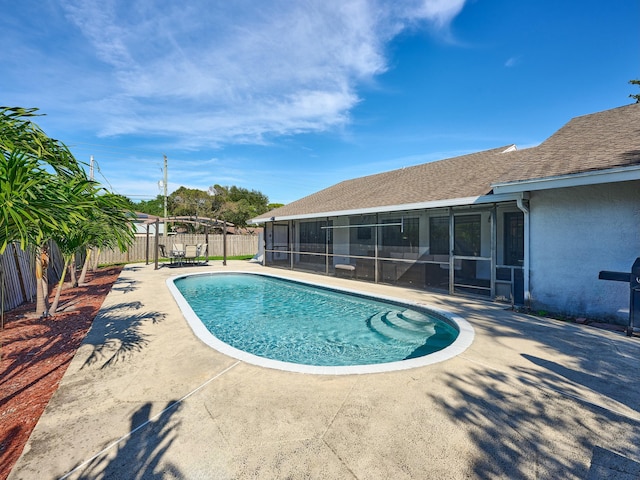 view of swimming pool featuring a patio area and a sunroom