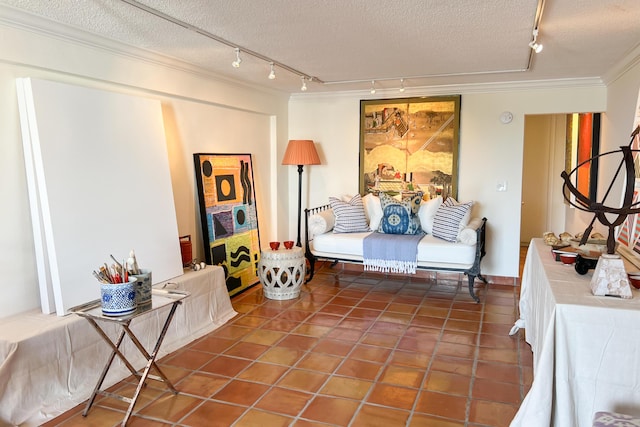 sitting room with tile patterned flooring, a textured ceiling, track lighting, and crown molding