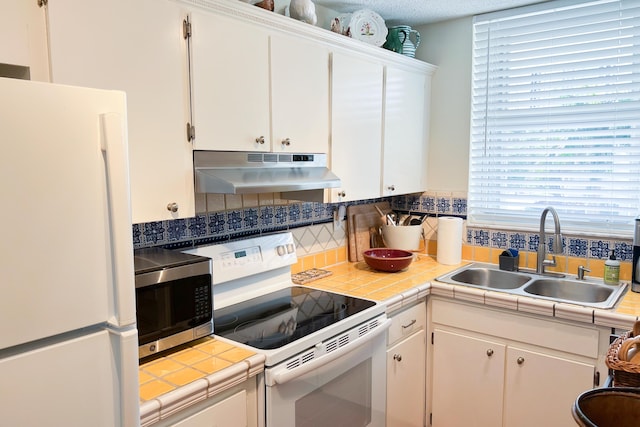 kitchen with white cabinets, tile counters, white appliances, and sink