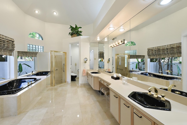 full bathroom featuring toilet, vanity, independent shower and bath, and high vaulted ceiling