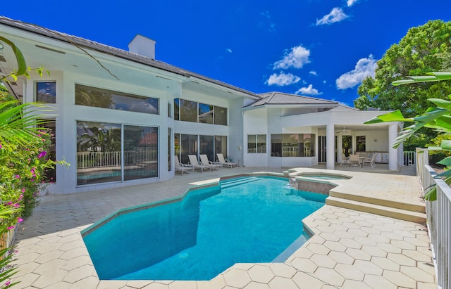 view of pool with ceiling fan, an in ground hot tub, and a patio