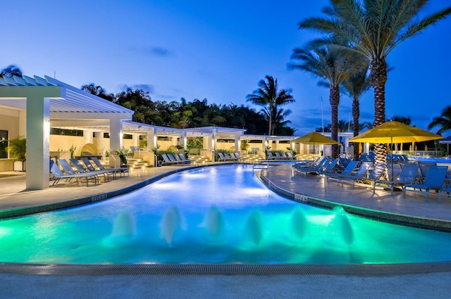 pool at dusk with a patio area