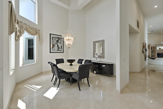 dining room with a towering ceiling and an inviting chandelier