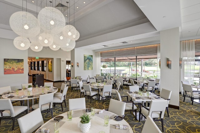 carpeted dining area featuring a high ceiling