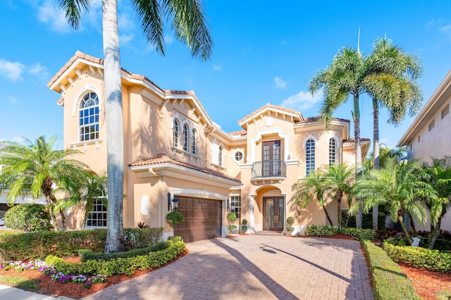 mediterranean / spanish house featuring french doors, a balcony, and a garage