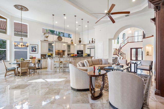 living room featuring a high ceiling, crown molding, and a wealth of natural light