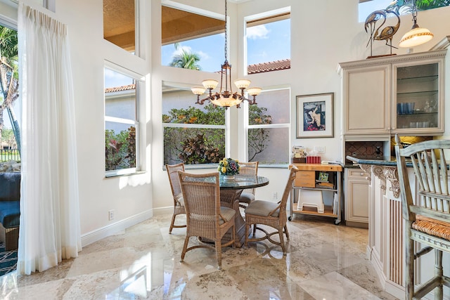 dining space featuring a towering ceiling and a chandelier