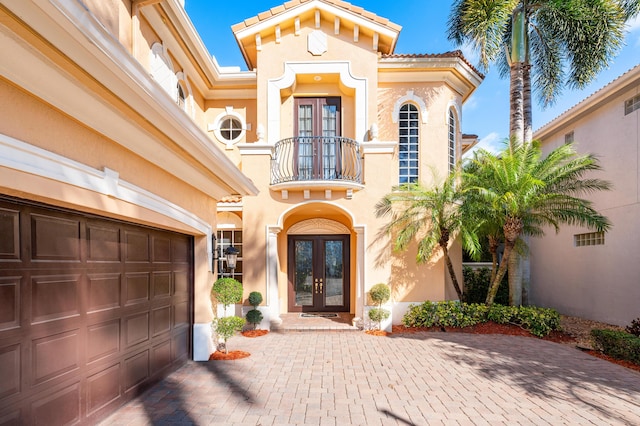 view of exterior entry featuring french doors and a garage