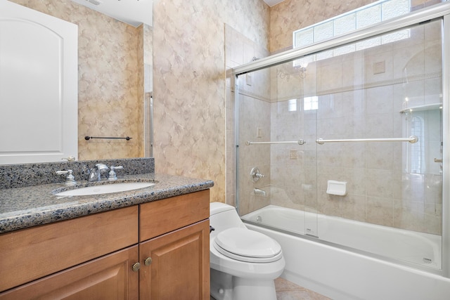 full bathroom featuring toilet, tile patterned flooring, vanity, and bath / shower combo with glass door