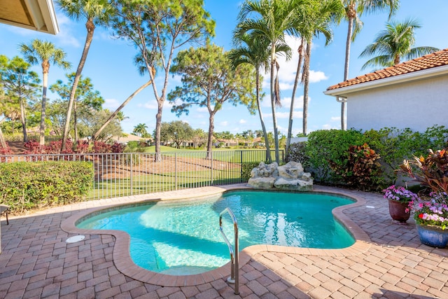 view of pool with a patio and a lawn