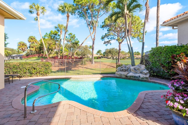 view of swimming pool featuring a patio area and a yard