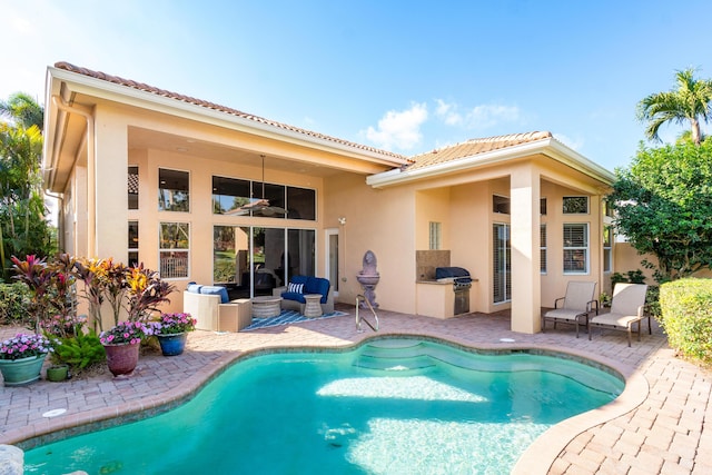 back of house with an outdoor kitchen and a patio area