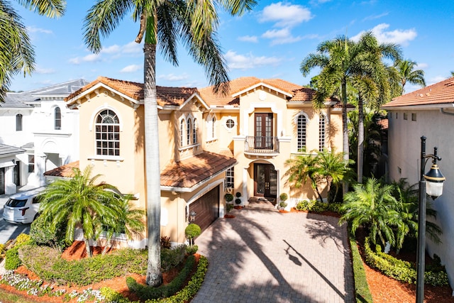 mediterranean / spanish house featuring a balcony, french doors, and a garage