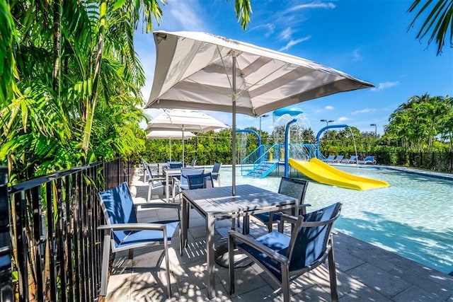 view of patio with a playground and a fenced in pool