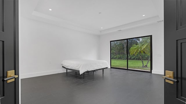 bedroom featuring access to exterior and a raised ceiling