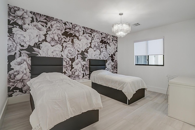 bedroom with light wood-type flooring and a chandelier